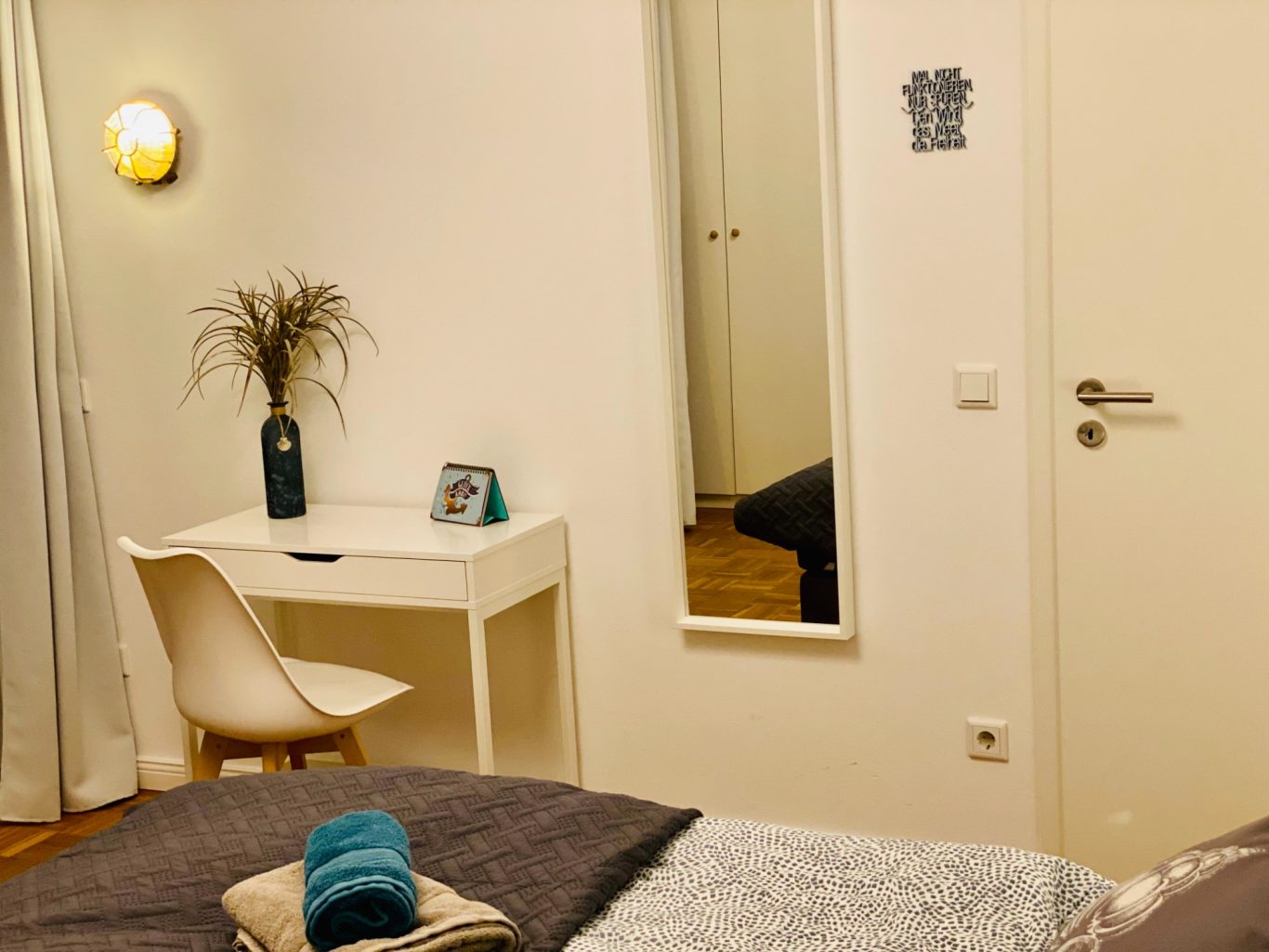 Schlafzimmer mit Arbeitsplatz in Sierksdorf Schlafzimmer mit Schminktisch oder Schreibtisch und Spiegel in der Ferienwohnung Sandkorn an der Ostsee