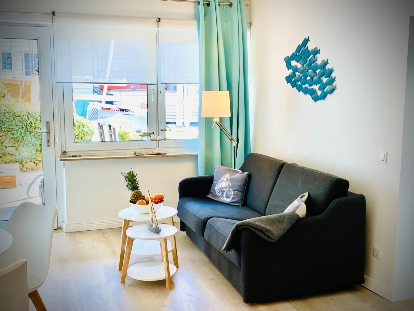 Wohnbereich mit Schlafsofa Gemütlicher Wohnbereich mit Sofa und Fenster in der Ferienwohnung Strandgut in Sierksdorf