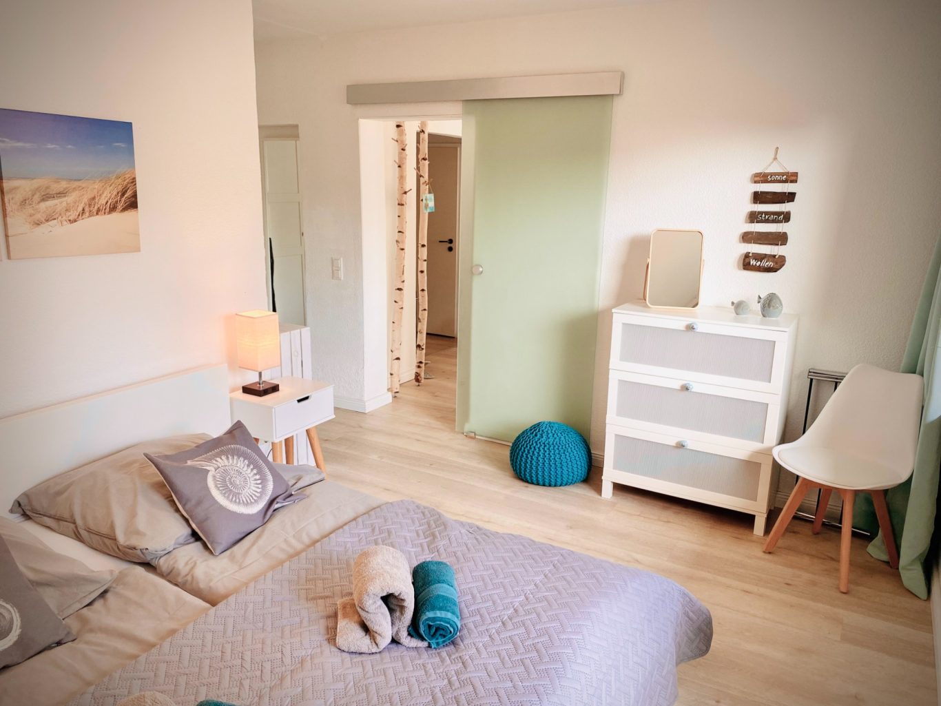 Schlafzimmer mit Doppelbett (1,80 x 2,00 Meter) und Zugang zum Wohnbereich & zur großen Terrasse Helles Schlafzimmer mit Blick in den Wohnbereich der Ferienwohnung Strandgut.
