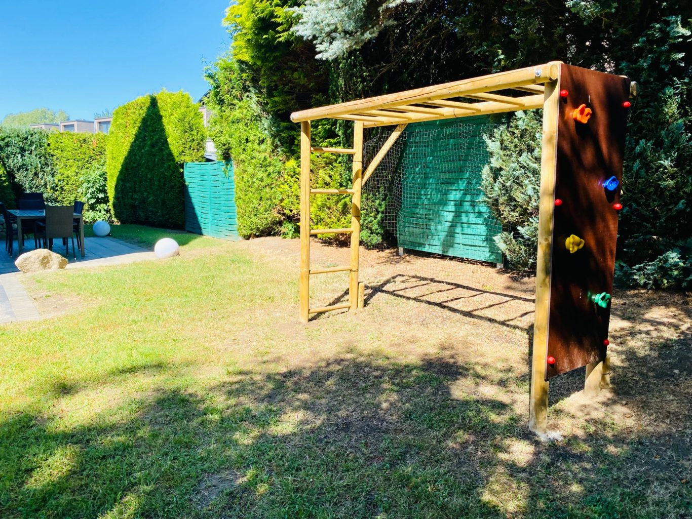 Viel Platz zum Spielen & Entspannen in Sierksdorf Spielplatz mit Klettergerüst und farbigen Griffen mit großem Garten in der Ferienwohnung Meeresbrise in der Lübecker Bucht