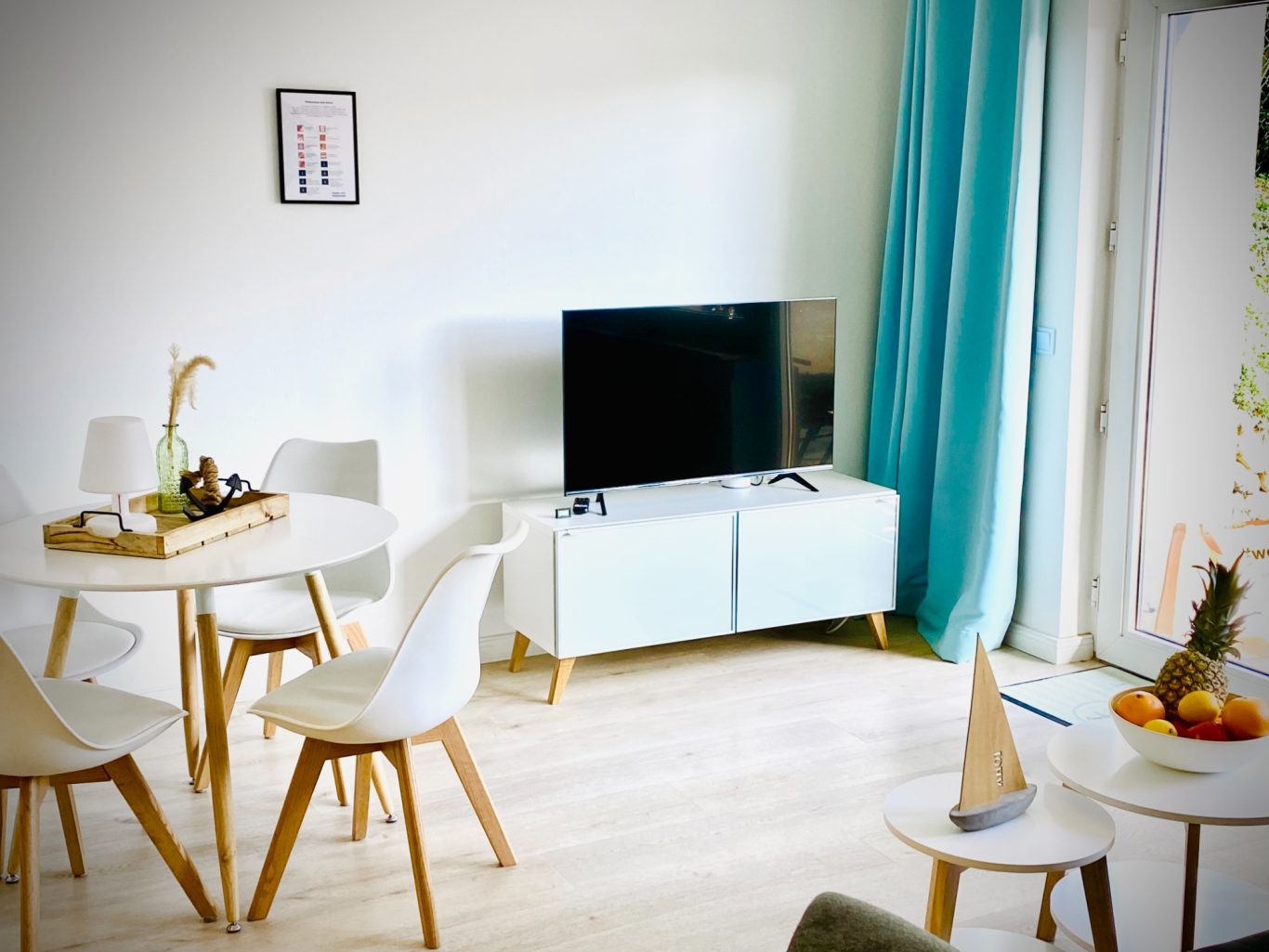 Offener Wohnbereich mit TV und Zugang zur Terrasse Wohn- und Essbereich mit TV und Sitzplatz in der Ferienwohnung Strandgut.
